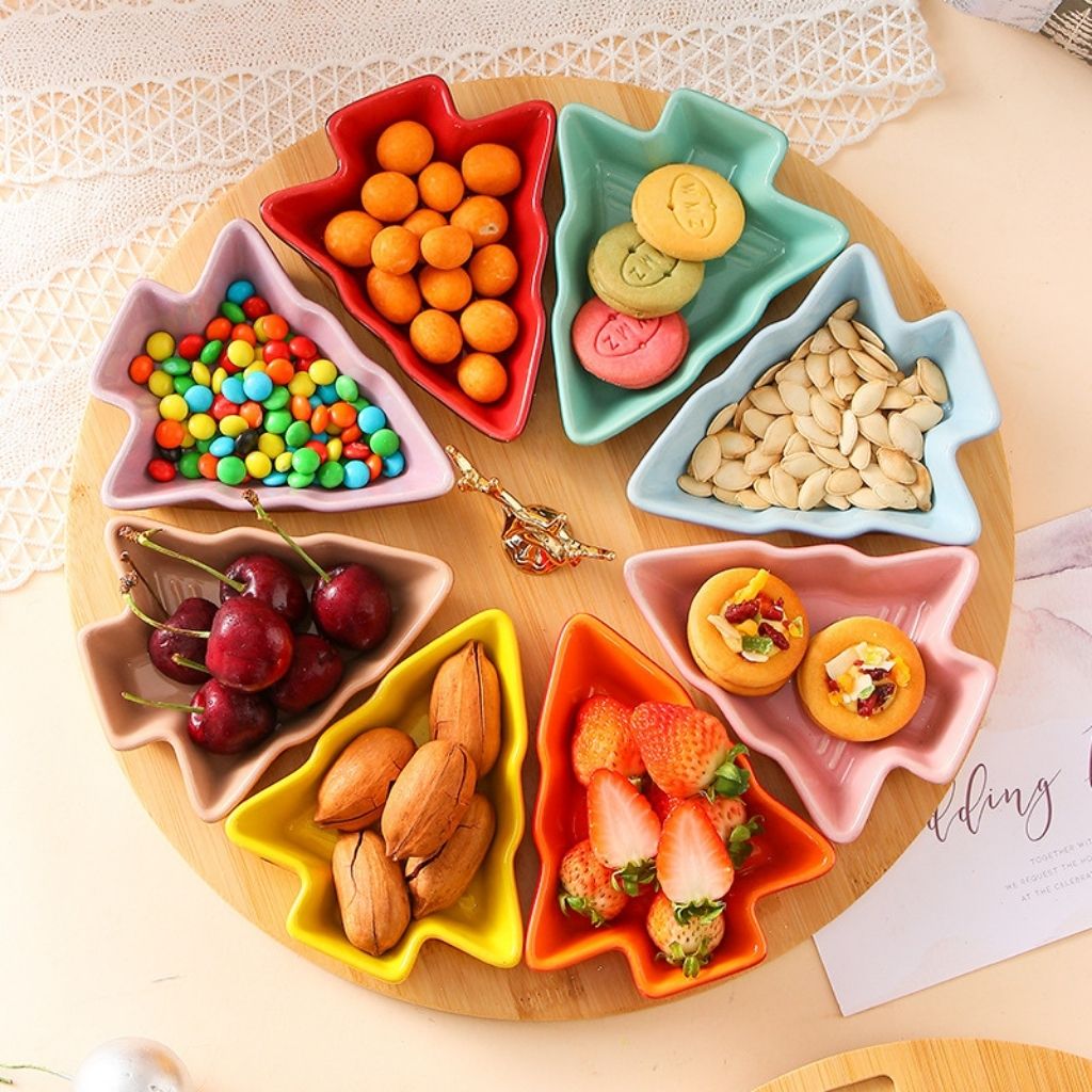 Tree shaped ceramic dishes filled with holiday snacks and fruits on festive table display