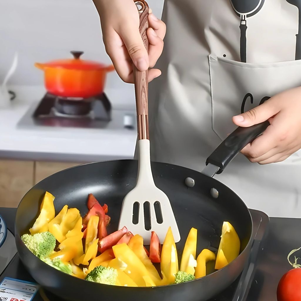 Modern silicone kitchen utensils featuring wood grain handles with gold finish for contemporary cooking style.