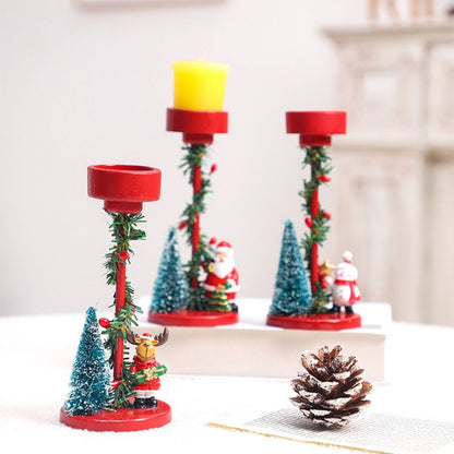 Festive candle holder with winter figurine and tree detail on white resin pedestal