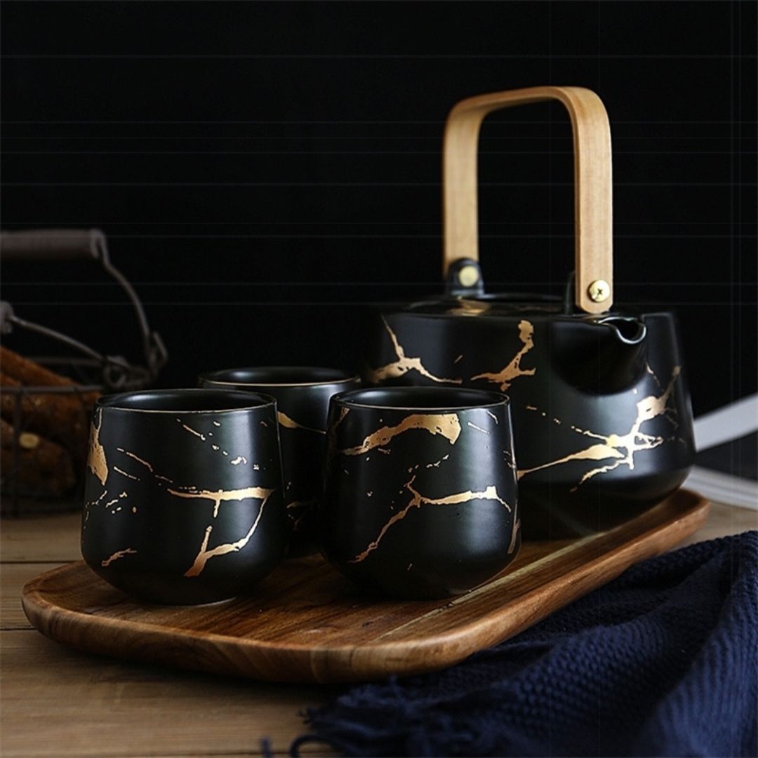 Ceramic marble teapot with ergonomic handle pouring tea into matching cup