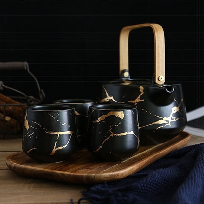 Ceramic marble teapot with ergonomic handle pouring tea into matching cup