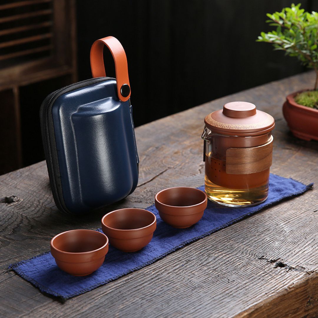 Travel tea set organized in protective carrying case with teapot and ceramic cups