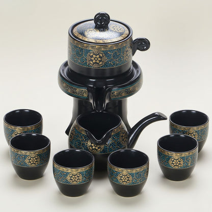 Ceramic teapot with matching cups featuring golden detailing on black glaze finish