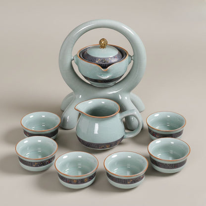 Ceramic rotating tea set with automatic pouring teapot and matching cups on wooden base