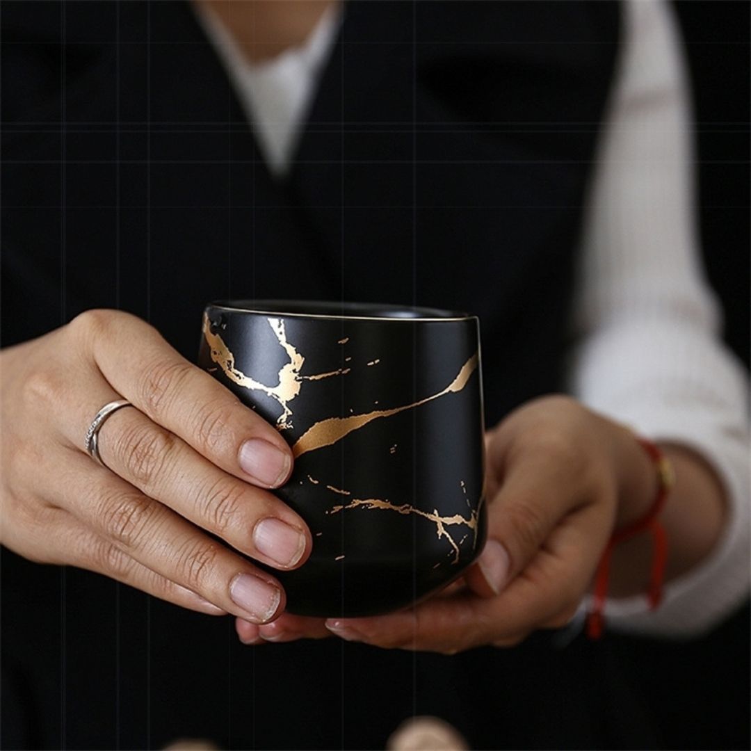 Overhead view of marble ceramic tea set with teapot four cups and tray