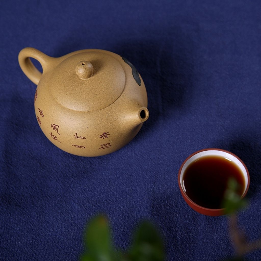 Full view of purple sand clay teapot with black hand painted calligraphy and compact design