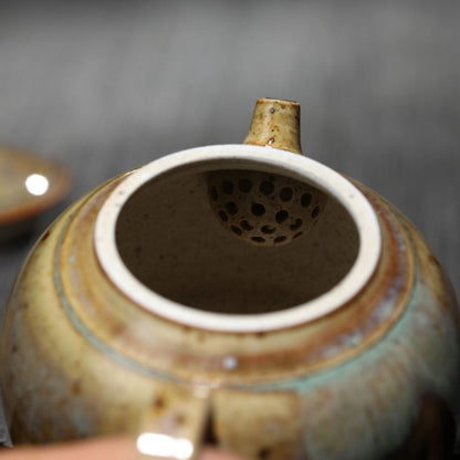 Artisan ceramic teapot with curved handle and smooth pouring spout in earth tones