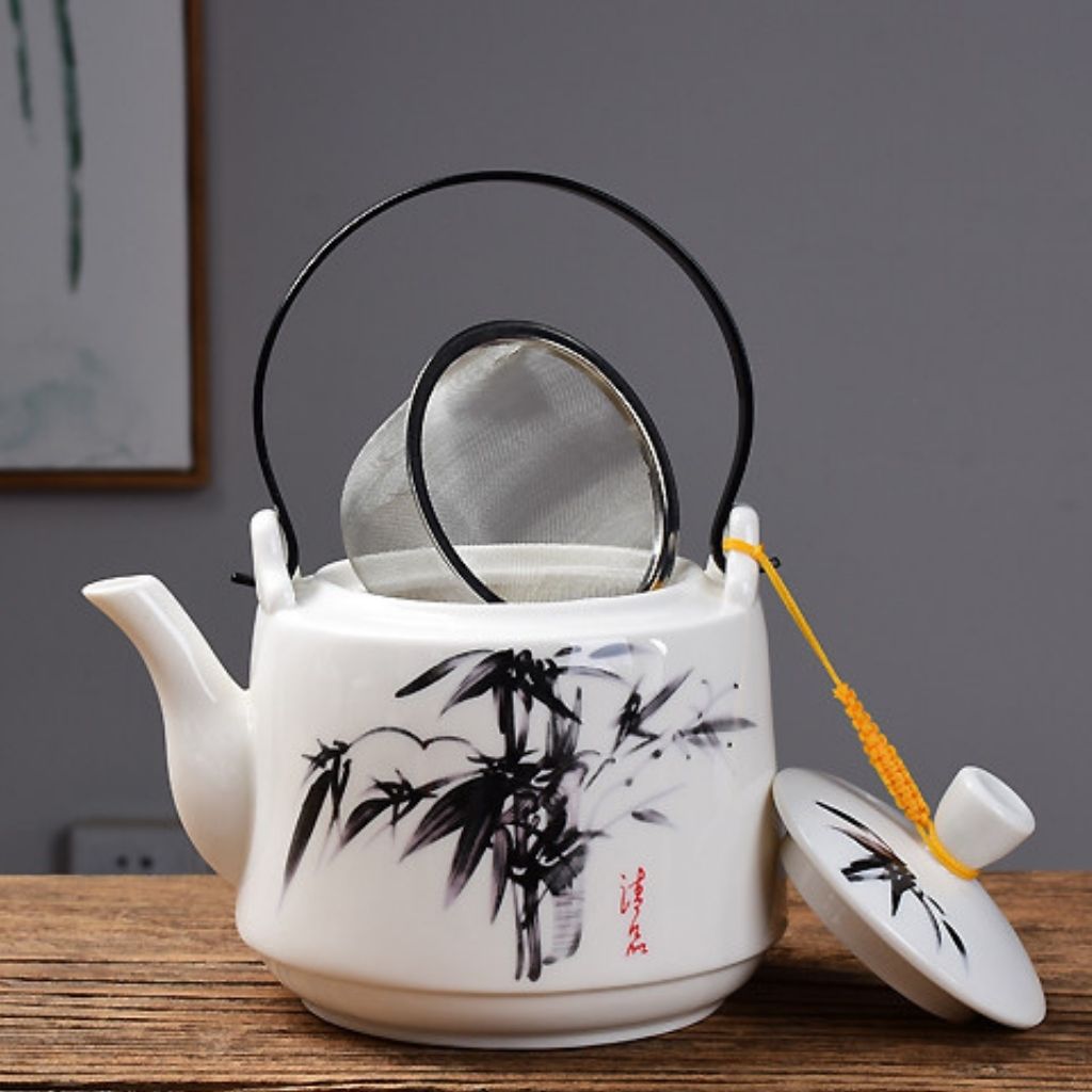 White ceramic teapot back view displaying full hand painted nature scene