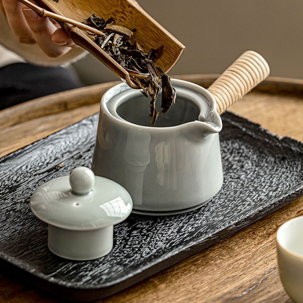 Glazed ceramic teapot with ergonomic side grip for controlled one hand pouring