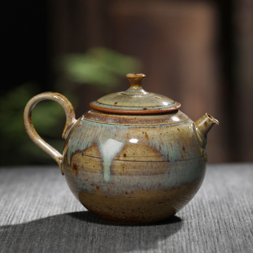 Side view of handmade ceramic teapot with balanced handle and glazed exterior