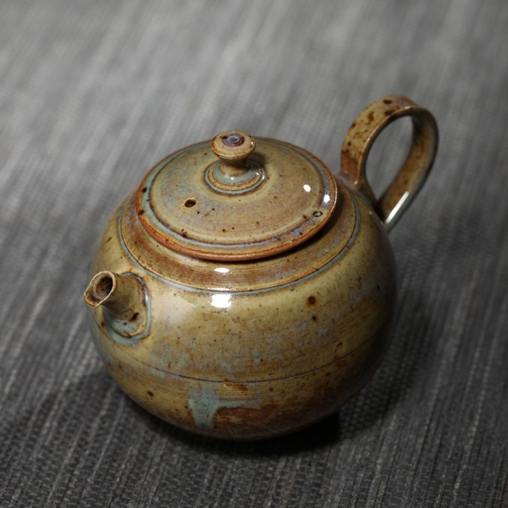 Top view of ceramic teapot with textured glaze and fitted lid opening