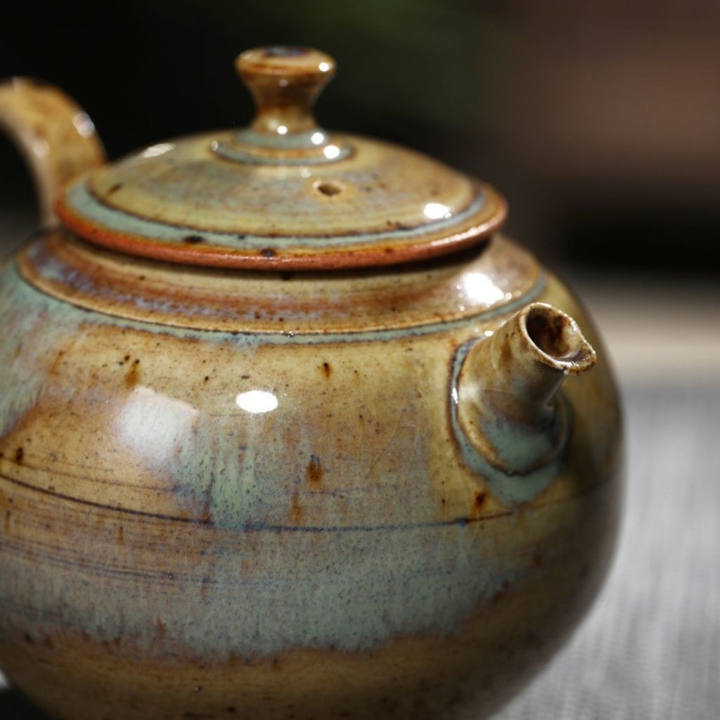 Glazed pottery teapot showing textured surface and natural color variations