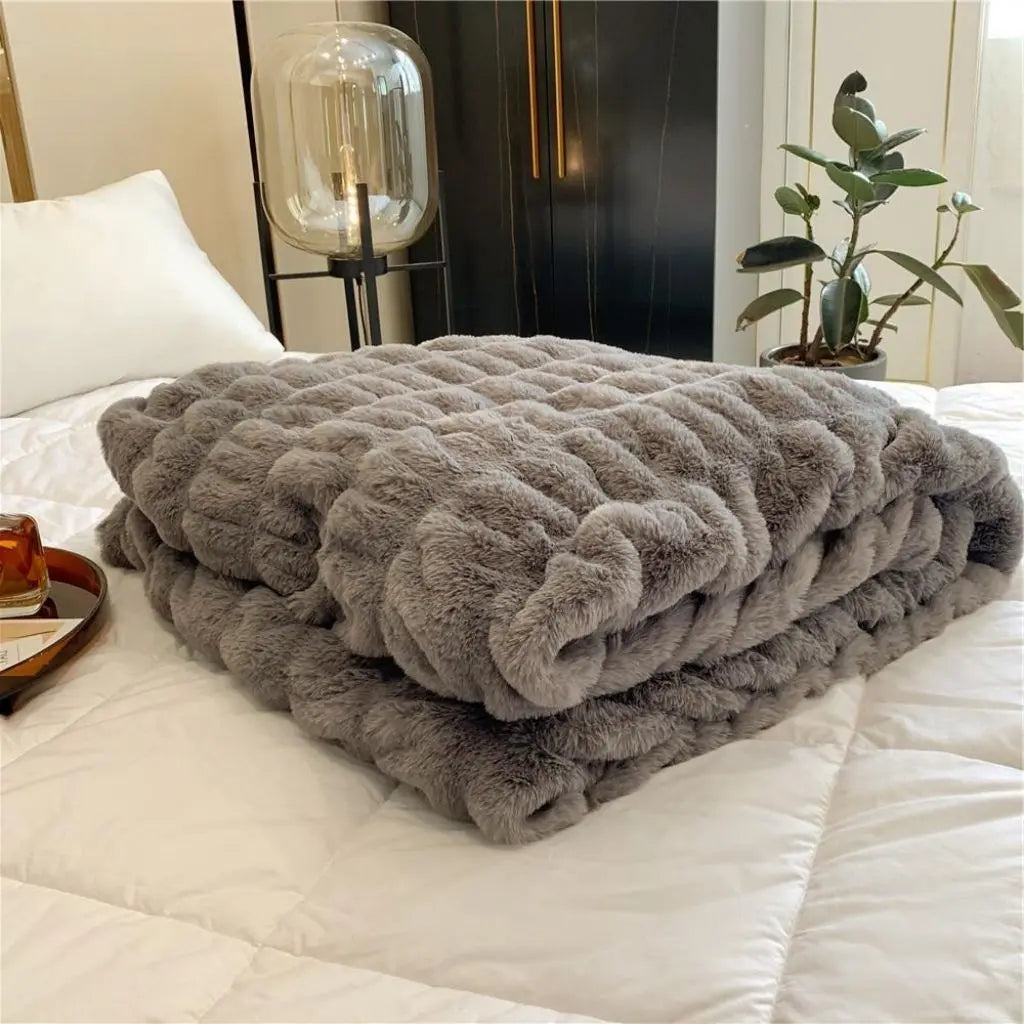 Textured fleece throw blanket layered on bed for warmth and comfort