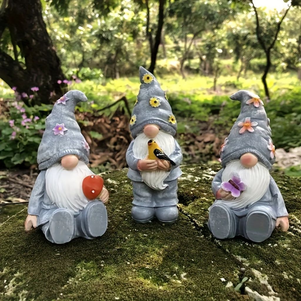 Resin garden gnome with blue hat and white beard standing among outdoor greenery