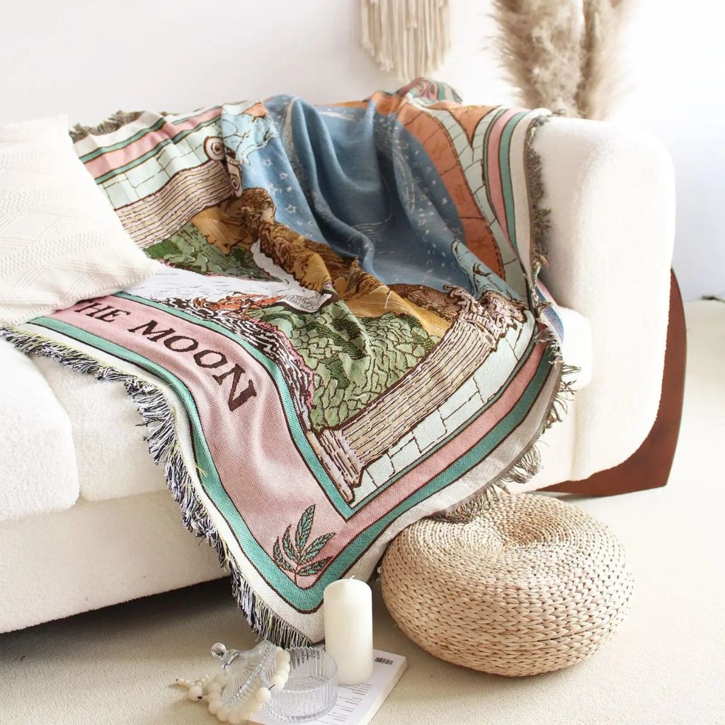 Decorative blanket with space-themed design on a couch