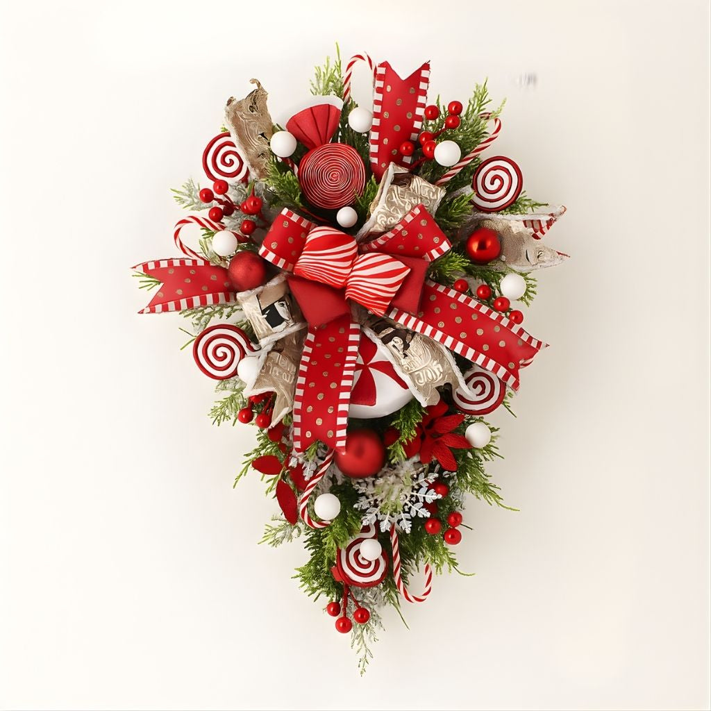 Christmas wreath with red berries and pine cones on white door